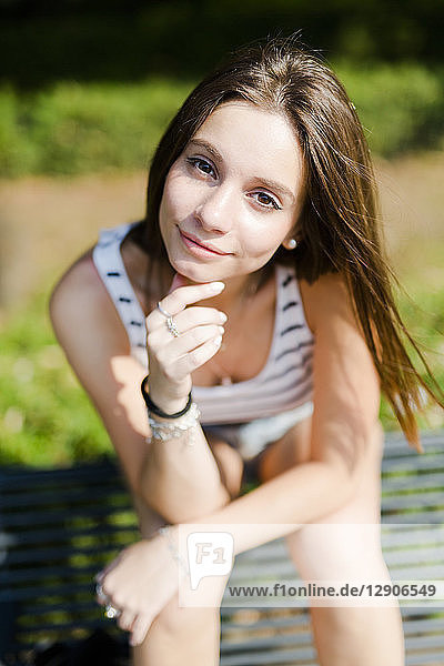 Portrait of smiling young woman sitting on a bench
