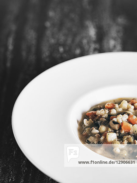 White dish with vegetable soup  partial view
