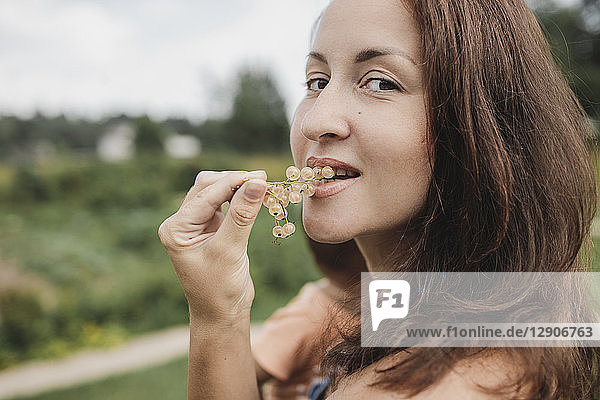 Portrait of woman eating white currants
