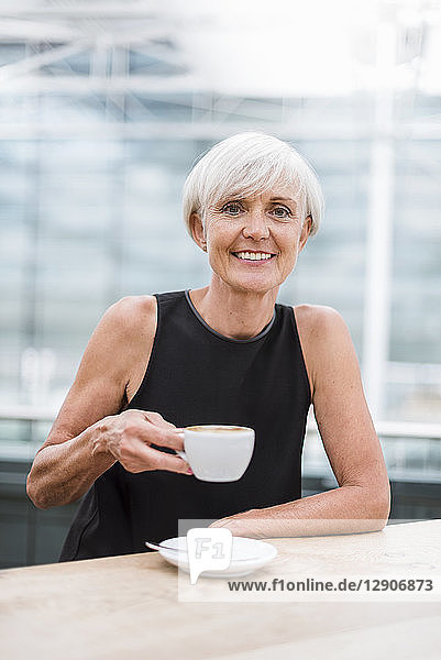 Portrait of smiling senior woman drinking a coffee
