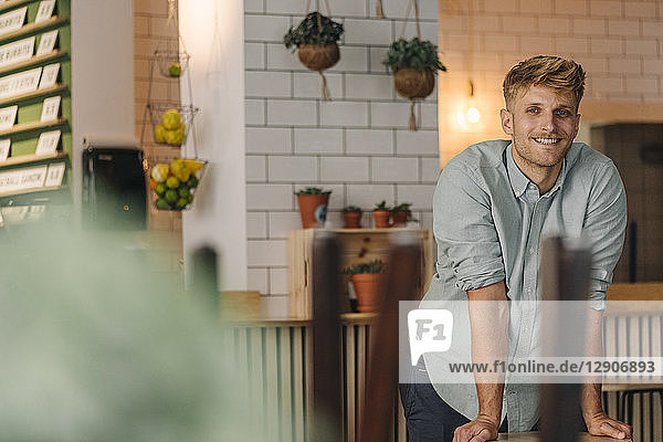 Young business owner standing in his coffee shop