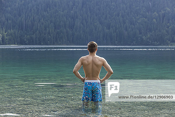 Germany  Bavaria  Eibsee  back view of young man standing in water