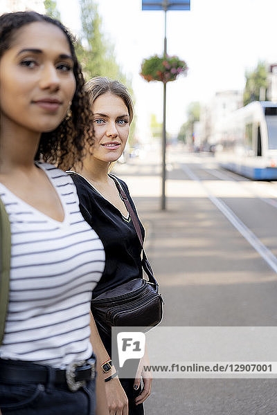 Two young women crossing street in the city