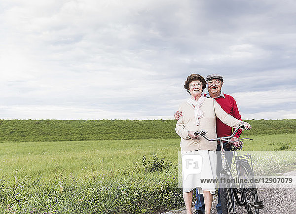 Senior couple with bicycles in rural landscape