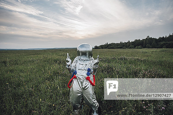 Spaceman exploring nature  standing in meadow  cheering