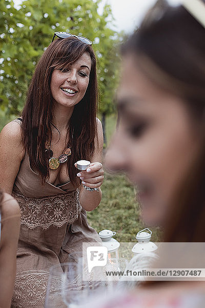 Friends preparing picnic in a vineyard  holding tea lights
