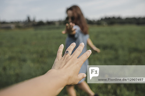 Hand reaching out for woman on a field