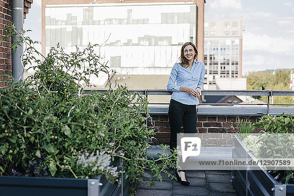 Businesswoman standing on her urban rooftop garden