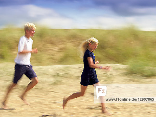 France  Bretagne  Sainte-Anne-la-Palud  La Plage de Treguer  brother and sister running on the beach
