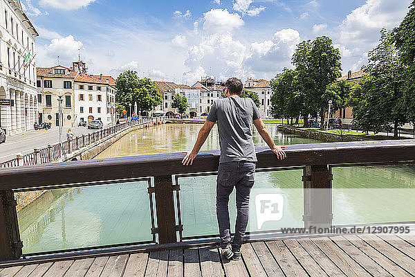 Italy  Veneto  Treviso  tourist looking on river