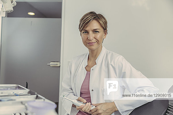 Female dentist holding electrical tooth brush