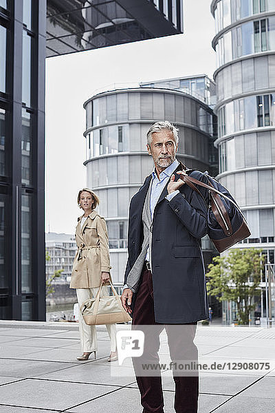 Germany  Duesseldorf  two fashionable business people with traveling bags