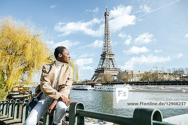 France  Paris  Smiling woman at river Seine with the Eiffel Tower in the background
