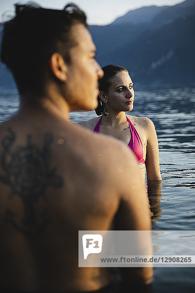 Young couple in a lake at sunset