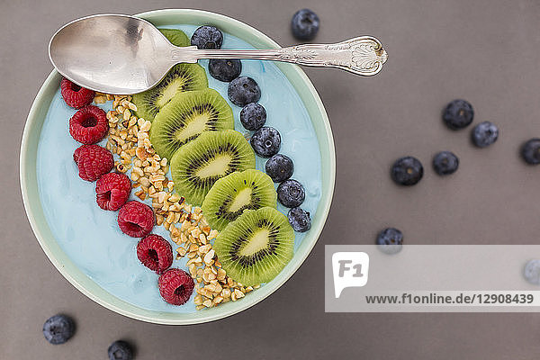 Smoothie bowl with blueberries  raspberries  kiwi and chopped hazelnuts