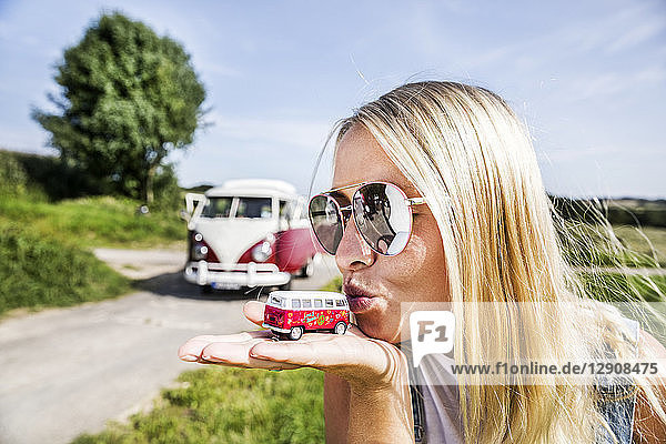 Woman wearing sunglasses kissing van model
