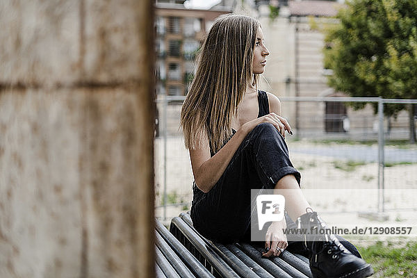 Pensive teenage girl sitting outdoors looking around