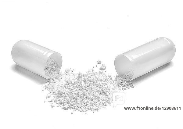 Opened white capsule and white powder on white background