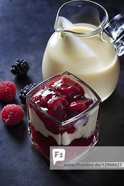 Red fruit compote with vanilla sauce layered in a glass