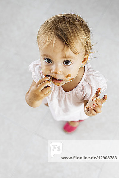 Portrait of little girl eating chocolate cookie
