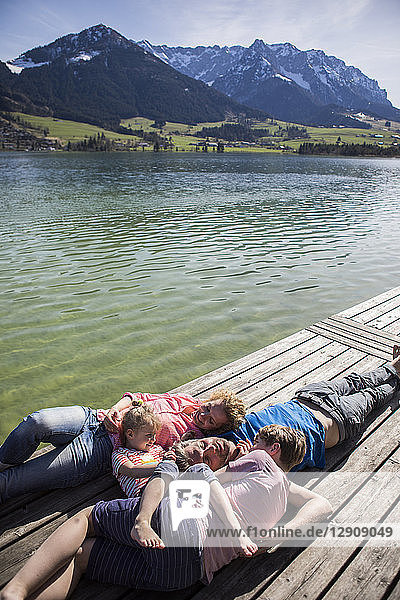 Austria  Tyrol  Walchsee  family lying on a jetty at the lakeside