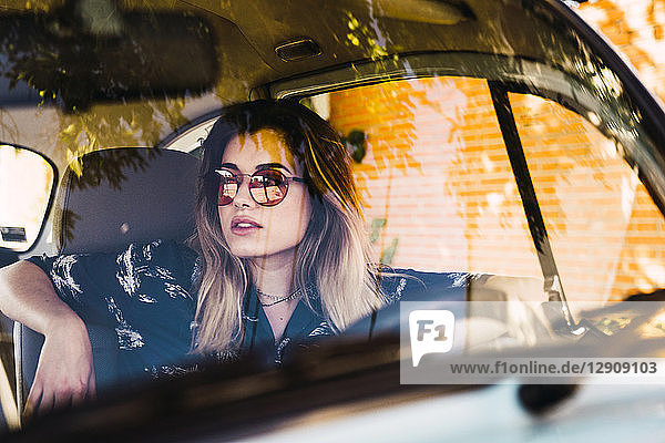 Young woman wearing sunglasses sitting in a car