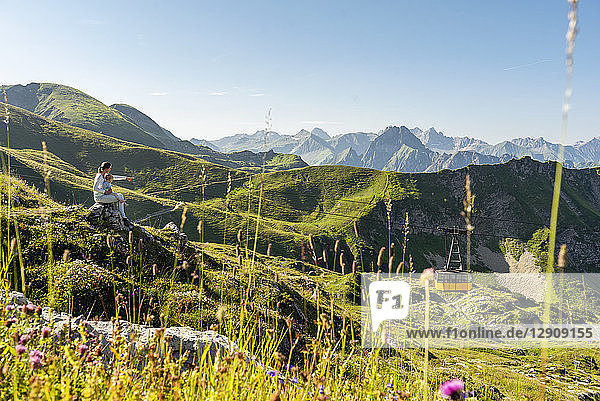 Germany  Bavaria  Oberstdorf  mother and little daughter on a hike in the mountains having a break looking at view