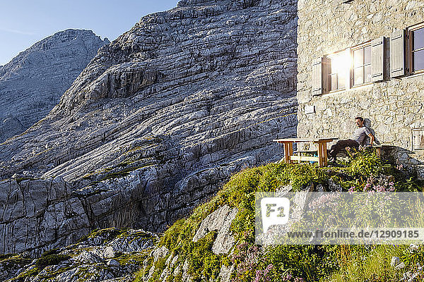 Austria  Salzburg State  Loferer Steinberge  hiker sitting at mountain hut enjoying the view