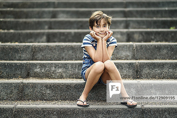 Portrait of relaxed little girl sitting on stairs