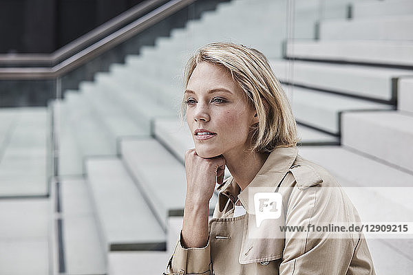 Portrait of blond businesswoman on stairs