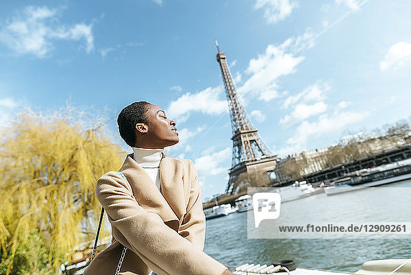 France  Paris  Woman with closed eyes at river Seine with the Eiffel Tower in the background