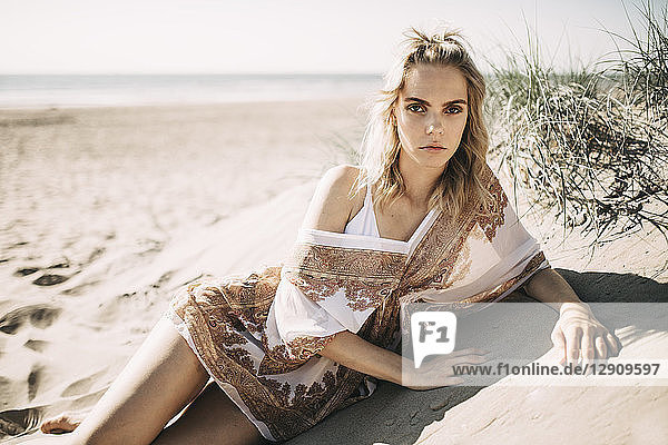 Portrait of a young woman lying in beach dune