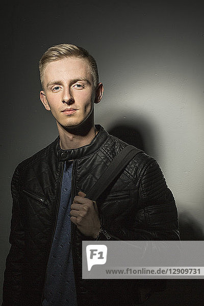 Portrait of young man wearing black leather jacket
