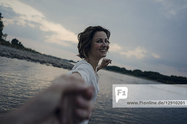 Laughing woman holding hands at the river