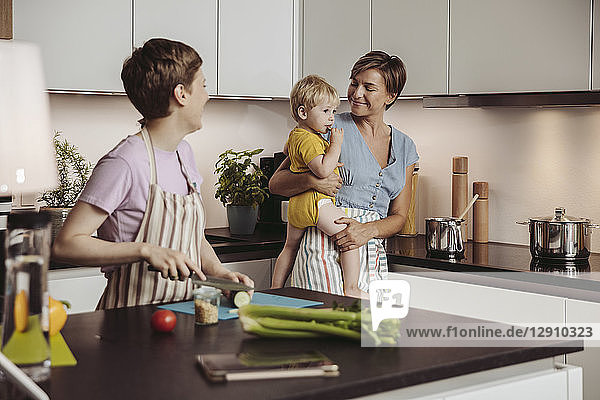 Happy lesbian couple and their child in kitchen