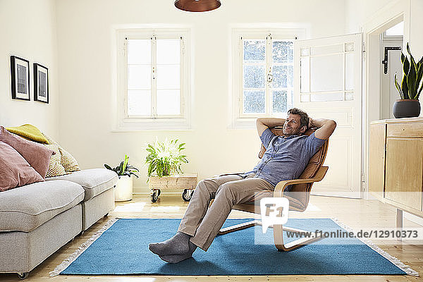 Man relaxing at home sitting in arm chair