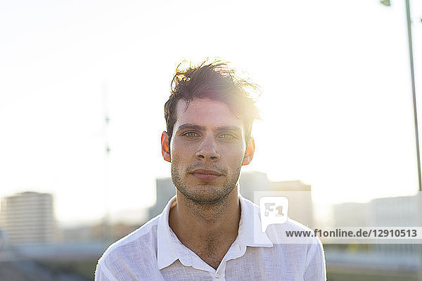 Portrait of handsome young man outdoors at sunset