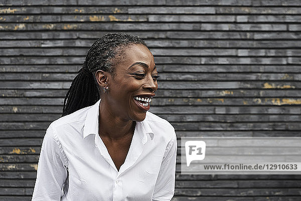 Portrait of laughing businesswoman wearing white shirt