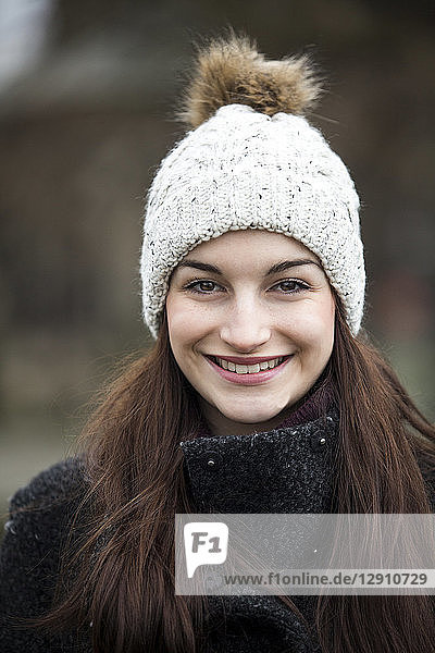 Portrait of smiling young woman wearing bobble hat