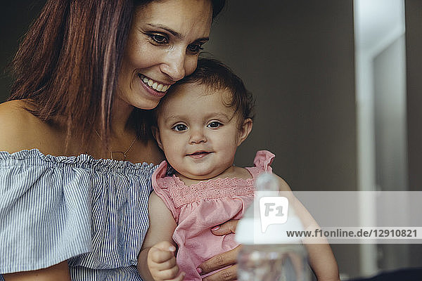 Mother offering her baby girl milk in a bottle