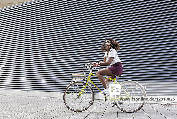 Smiling young woman riding bicycle
