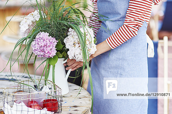 Woman decorating the table with flowers