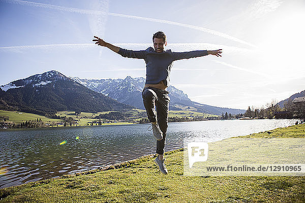 Austria  Tyrol  Walchsee  happy man jumping at the lake