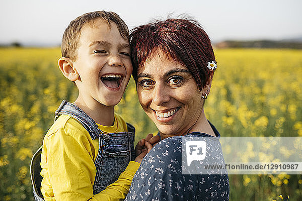 Portrait of mother and little son in a rape field