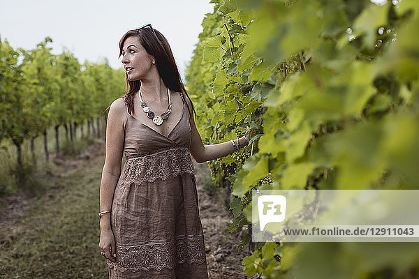 Woman standing in vineyard  wearing summer dress