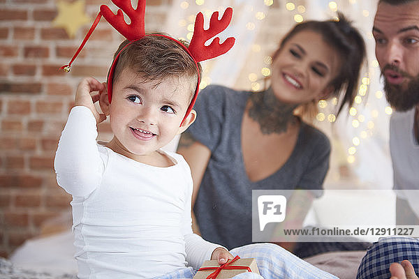 Cute boy in reindeer costume at Christmas time in bed