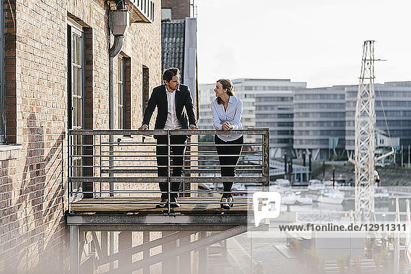 Business people standing on balcony  discussing