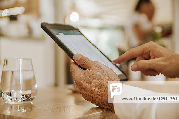 Close-up of man using tablet in a cafe