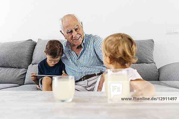 Portrait of grandfather spending time with his grandson and granddaughter