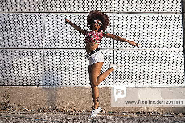 Portrait of fashionable woman jumping in the air